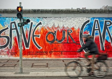 Man on a bicycle in Berlin at the East Side Gallery